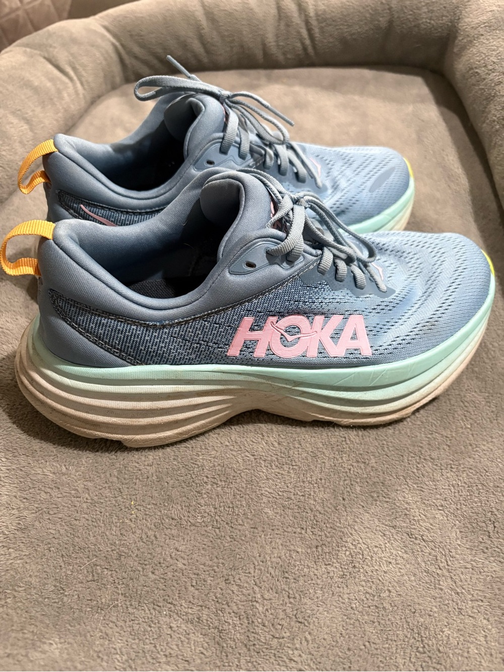 Hoka Sky Blue Running Shoes with Pink Logo and Yellow Heel Tab